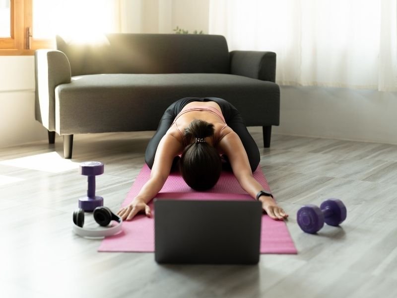 Laptop screen showing an online workout session with a virtual fitness instructor